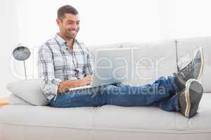 Relaxing man on a sofa with a laptop