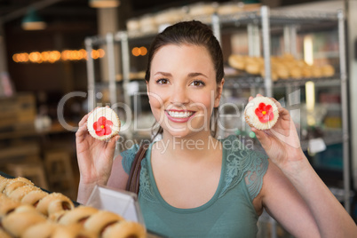 Pretty brunette showing a cupcake