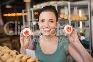 Pretty brunette showing a cupcake