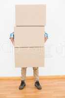 Man carrying pile of cardboard moving boxes