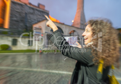 Blurred zoomed view of a happy girl pointing to a Istanbul landm