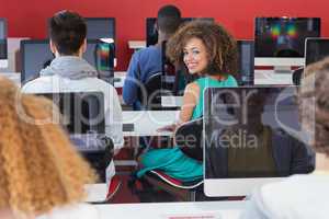 Student smiling at camera in computer class