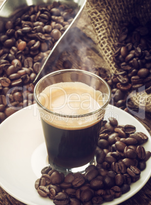 Espresso coffee in glass cup with coffee beans.