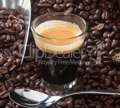 Espresso coffee in glass cup with coffee beans.