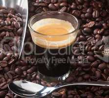 Espresso coffee in glass cup with coffee beans.