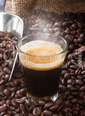 Espresso coffee in glass cup with coffee beans.