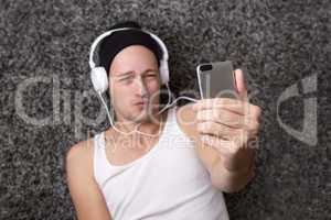 Attractive man with headphones makes selfie with his mobile