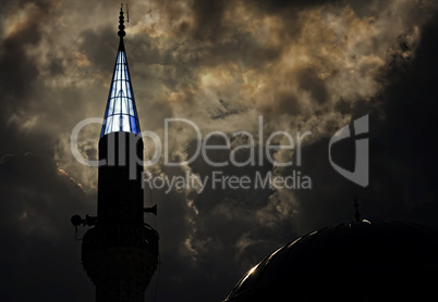 Turkish mosque at dusk with sunlight behind turret