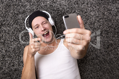 Attractive man with headphones makes selfie with his mobile