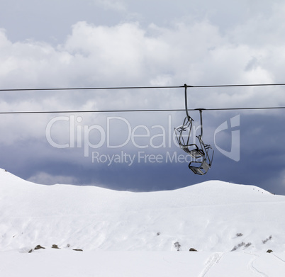 Chair lifts and off piste slope at gray day