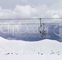 Chair lifts and off piste slope at gray day