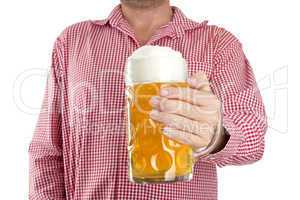 Man in traditional Bavarian shirt holds mug of beer