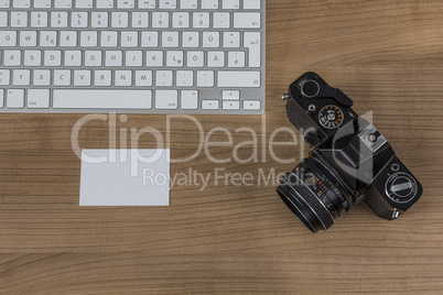 Camera keyboard and business card on a desktop