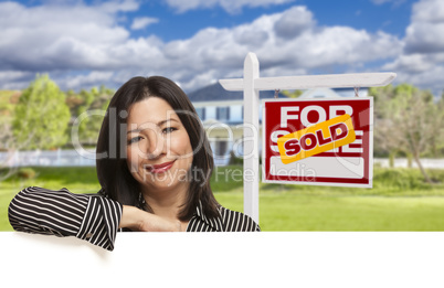Hispanic Woman in Front of Sold For Sale Sign, House