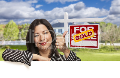 Hispanic Woman in Front of Sold For Sale Sign, House