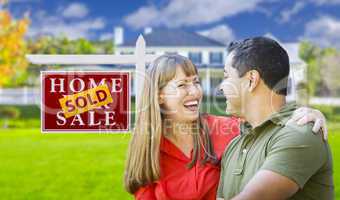 Couple in Front of Sold Real Estate Sign and House