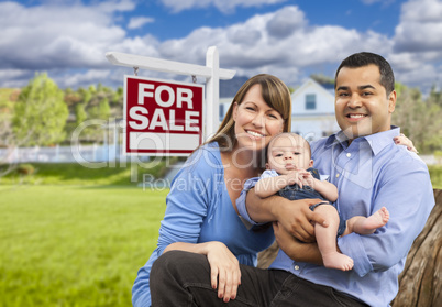 Young Family in Front of For Sale Sign and House