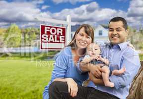 Young Family in Front of For Sale Sign and House