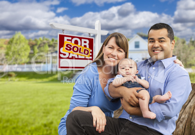 Young Family in Front of Sold Real Estate Sign and House