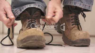 Male Putting On Old Workboot