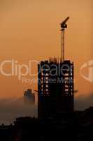 Dawn silhouette of office block with crane