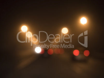 blurred lights of cars on the road in the fog