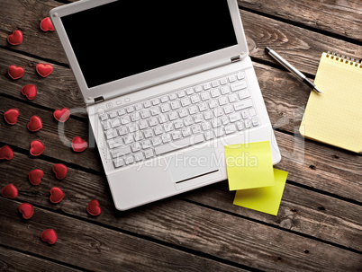White laptop and hearts with sticky notes