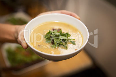 Hand mit Schüssel mit Suppe