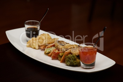 Tempura vegetable platter with glasses of sauce