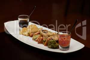 Tempura vegetable platter with glasses of sauce