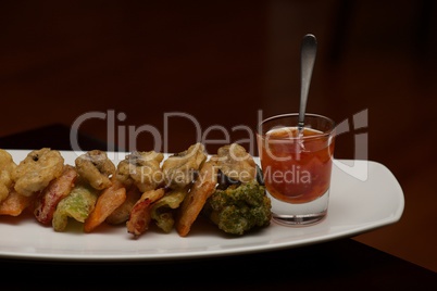 Tempura vegetable platter with glass of sauce