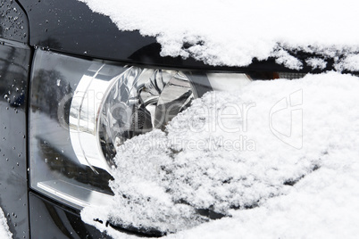 Snowed car headlights in winter