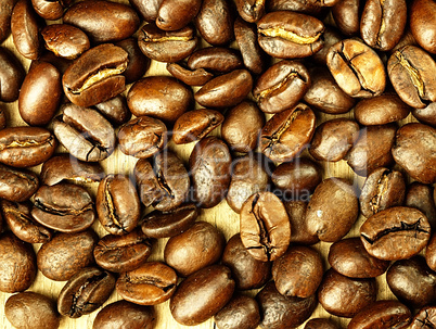 Coffee beans close-up on wooden, oak table.