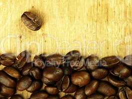 Coffee beans close-up on wooden, oak table.