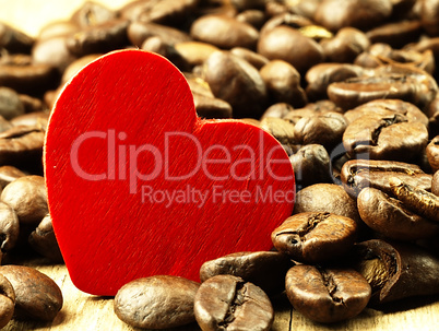 Heart and Coffee beans close-up on wooden, oak table.