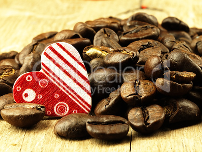 Heart and Coffee beans close-up on wooden, oak table.