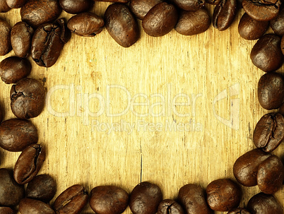 Coffee beans close-up on wooden, oak table.