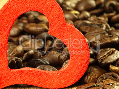 Heart and Coffee beans close-up on wooden, oak table.