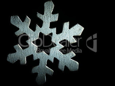 Huge white wooden snowflake and black background.