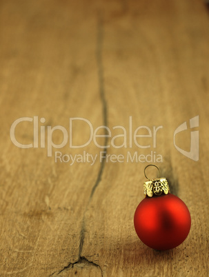 Red Christmas bauble on a wooden oak background.