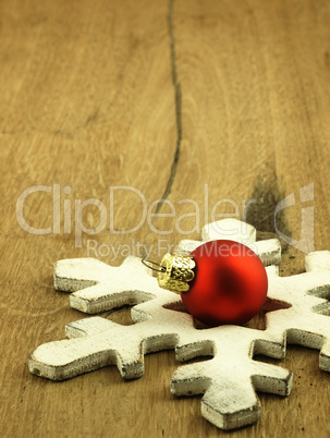 Red Christmas bauble on a wooden oak background.