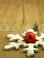 Red Christmas bauble on a wooden oak background.