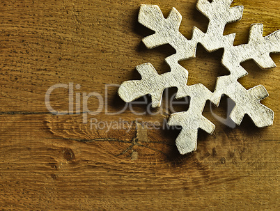 Huge white snowflake and wooden background.