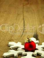 Red Christmas bauble on a wooden oak background.