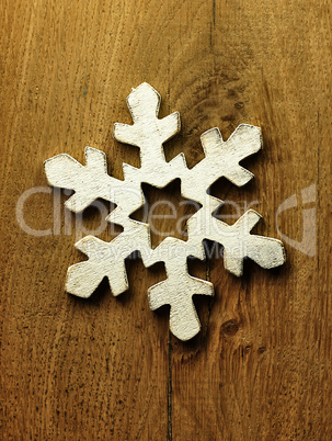 Huge white snowflake and wooden background.