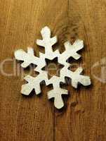 Huge white snowflake and wooden background.