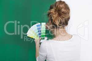 Frau mit Farbtafeln vor gruener Wand