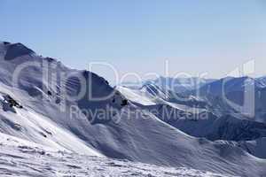 Off-piste slope and snowy mountains in morning