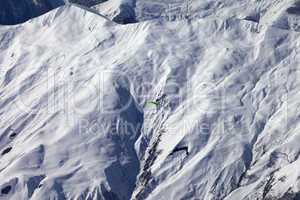 Off-piste slope and paraglider in nice day