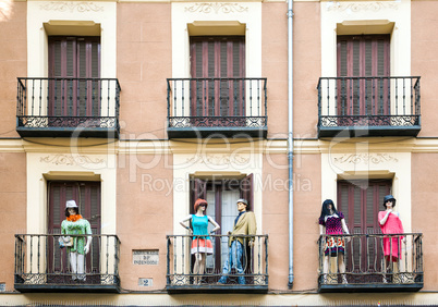 Building with dresed manequins on balconies on a street of Madri